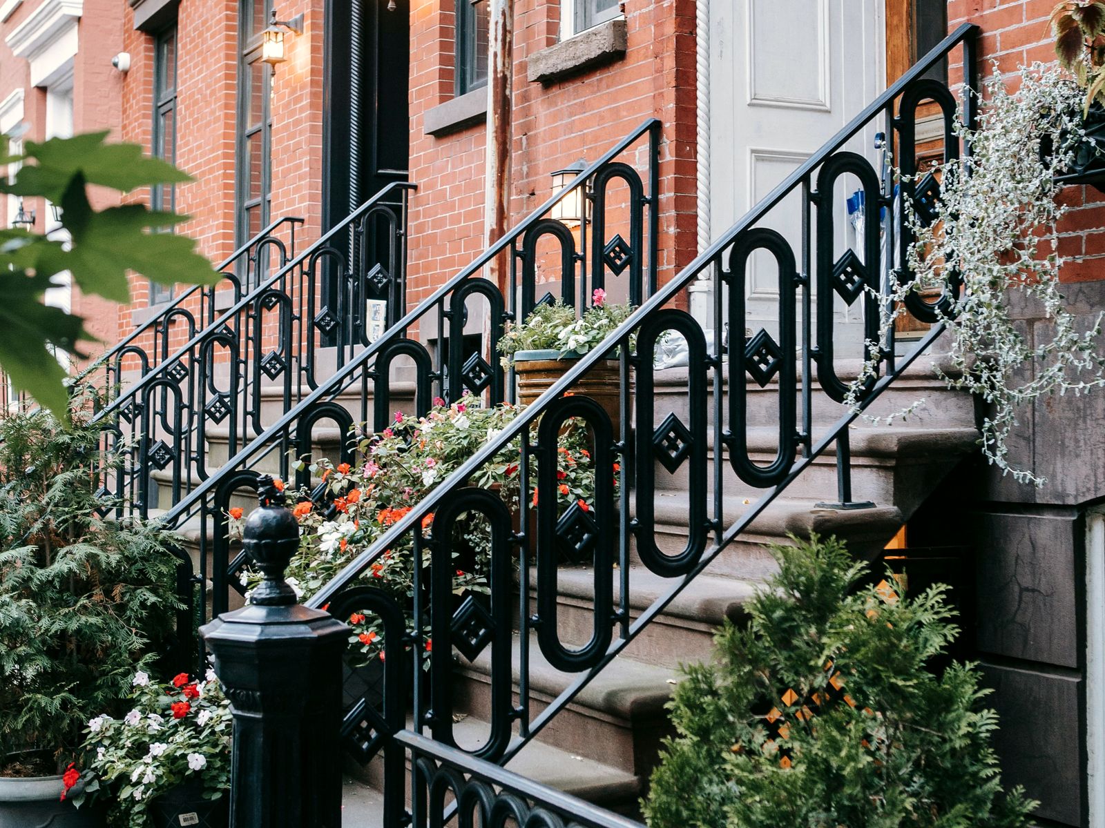 Ornate wrought-iron stoop railing with flowers, Brooklyn brownstone